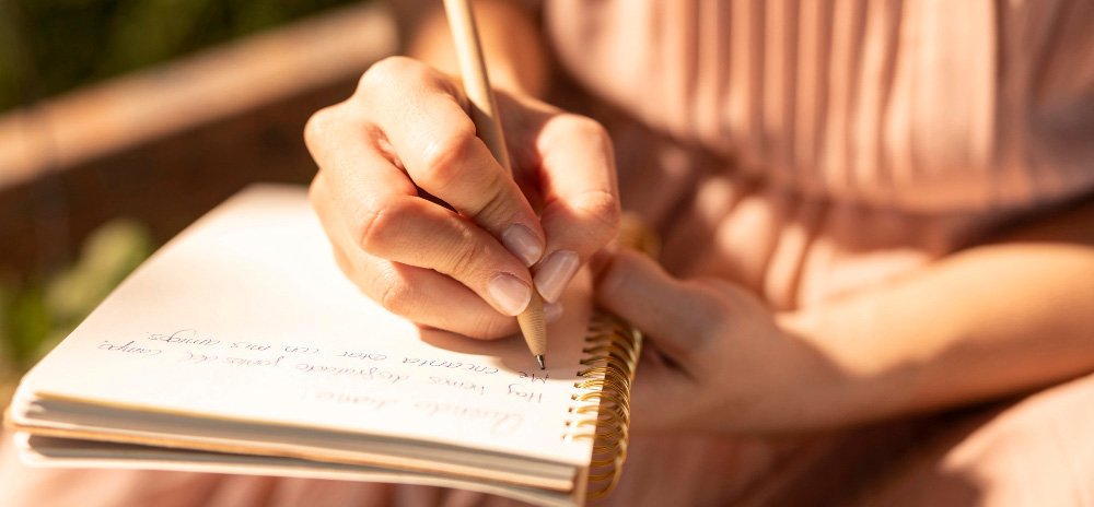 persoon die schrijft of mediteert bij zacht zonlicht, symbool voor innerlijke groei en mentale training